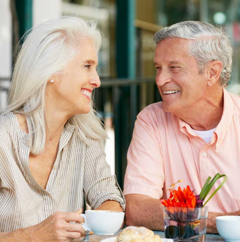 Older couple having a coffee and enjoying life despite having hearing loss. 